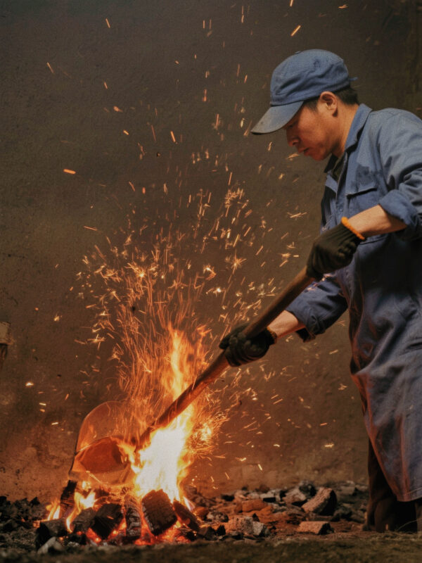 Tea maker roasting Wuyi oolong over charcoal fire, shaping the character and stability of Dahongpao tea