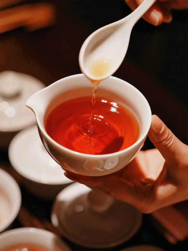Pouring freshly brewed Dahongpao tea, highlighting its steady body feel and calming nature across infusions
