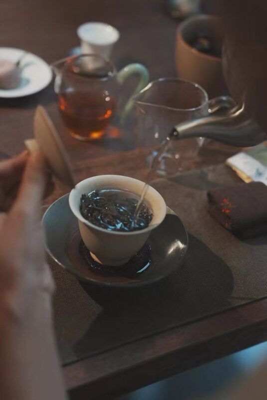 Calm indoor tea session with Wuyi rock tea brewing in traditional teaware, showing a serene and focused tea moment.