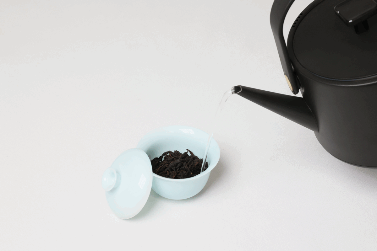 Instruction image showing correct gaiwan pouring in a portable porcelain gongfu tea set, including inner-wall pouring, comfortable grip, moderate opening, and natural tea flow