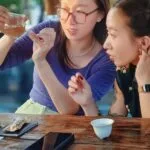 Two friends discussing tea flavor during an outdoor tea session