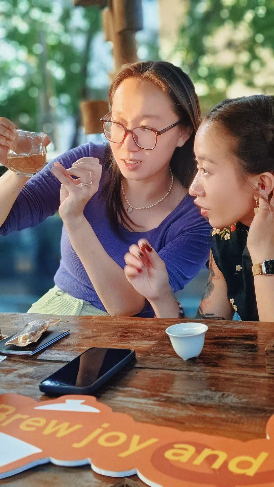 Two friends discussing tea flavor during an outdoor tea session