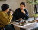 Two people drinking Chinese tea indoors after a meal, illustrating how black tea and rock tea fit different post-meal situations