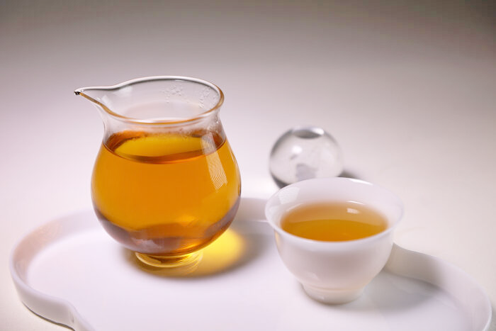 Huang Guan Yin Wuyi rock tea served in a small cup as a balanced baseline tea for beginners learning roast, aroma, and body.