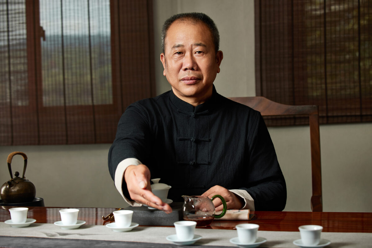 Liu Dexi, a Wuyi rock tea charcoal roasting master, serving tea during a traditional tasting session.