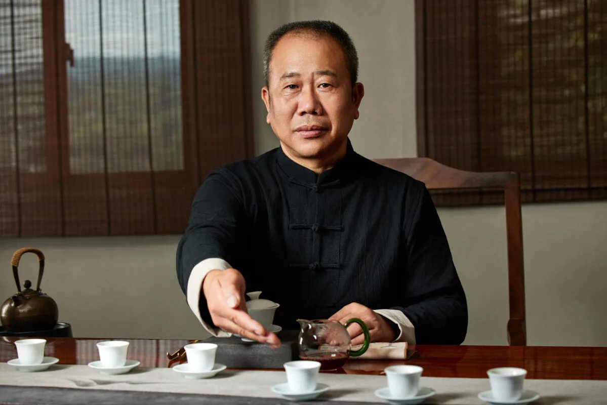 Liu Dexi, a Wuyi rock tea charcoal roasting master, serving tea during a traditional tasting session.
