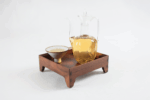 Hengxian Jasmine Tea brewed in a glass cup on a wooden tea tray.
