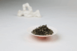 Dry Hengxian Jasmine Tea leaves displayed on a small dish.