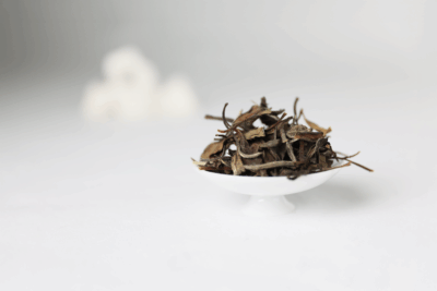 Dry leaves of Jianyang Bai Mu Dan white tea with silvery buds and tender leaves.