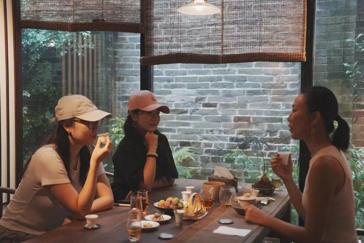 Charlotte Yao and Ling Chen sharing tea with a friend at their first meeting in 2024