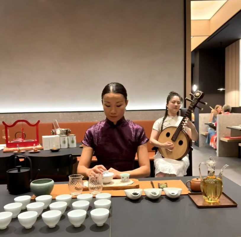 Ling Chen presenting Chinese tea alongside a traditional Chinese music performance in Milan