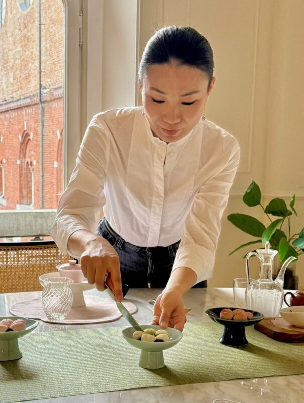 Ling Chen preparing sweets and teaware for a Chinese tea gathering in Milan