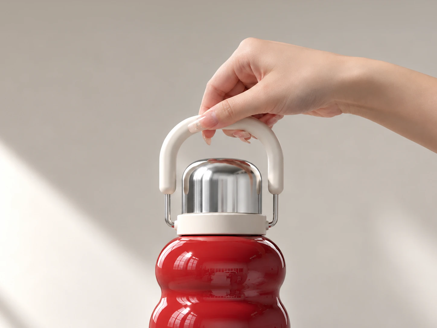Red Lucky Gourd tea bottle lifted by its large folding handle