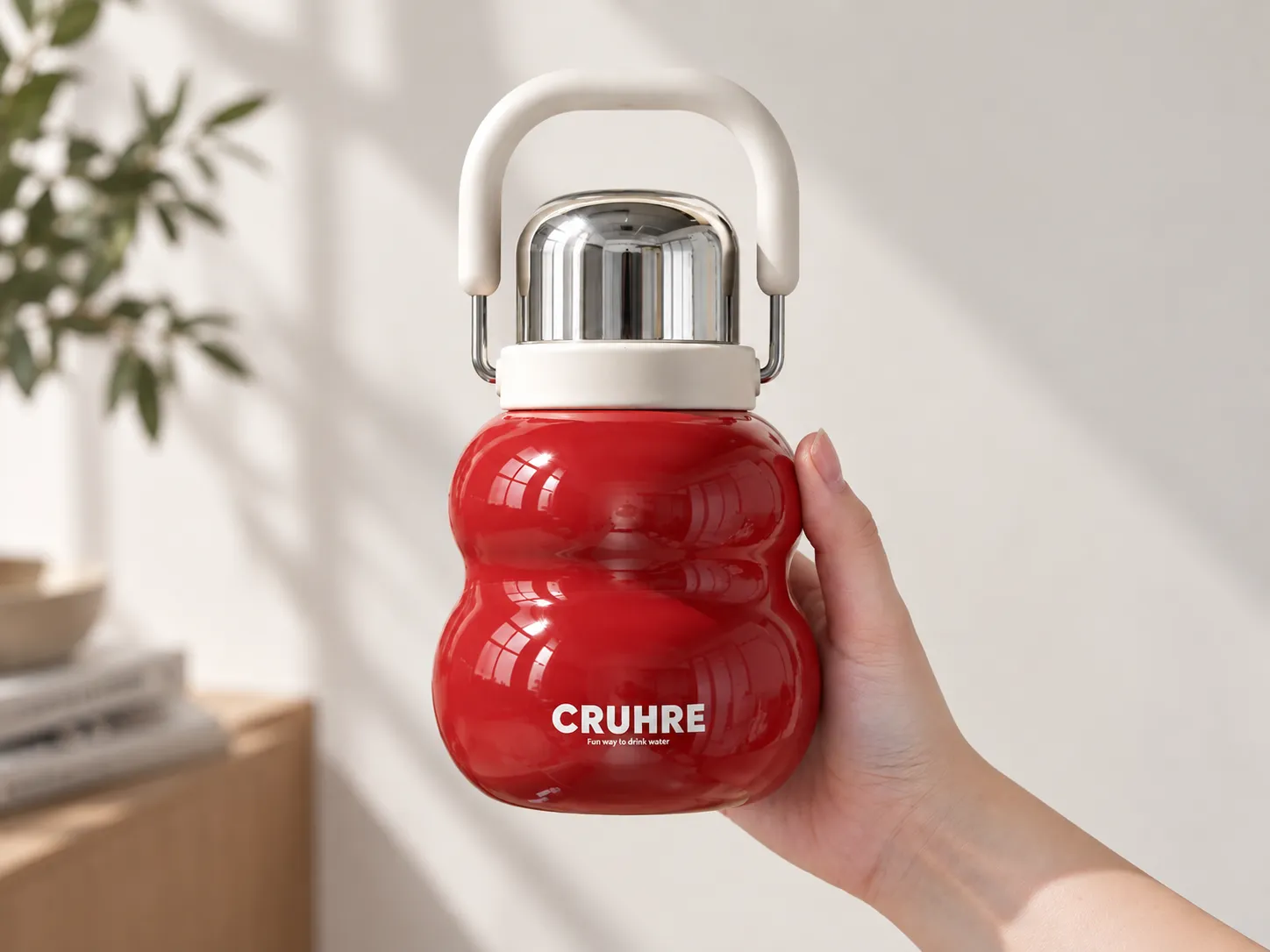 Hand holding a red gourd-shaped tea bottle with rounded curves